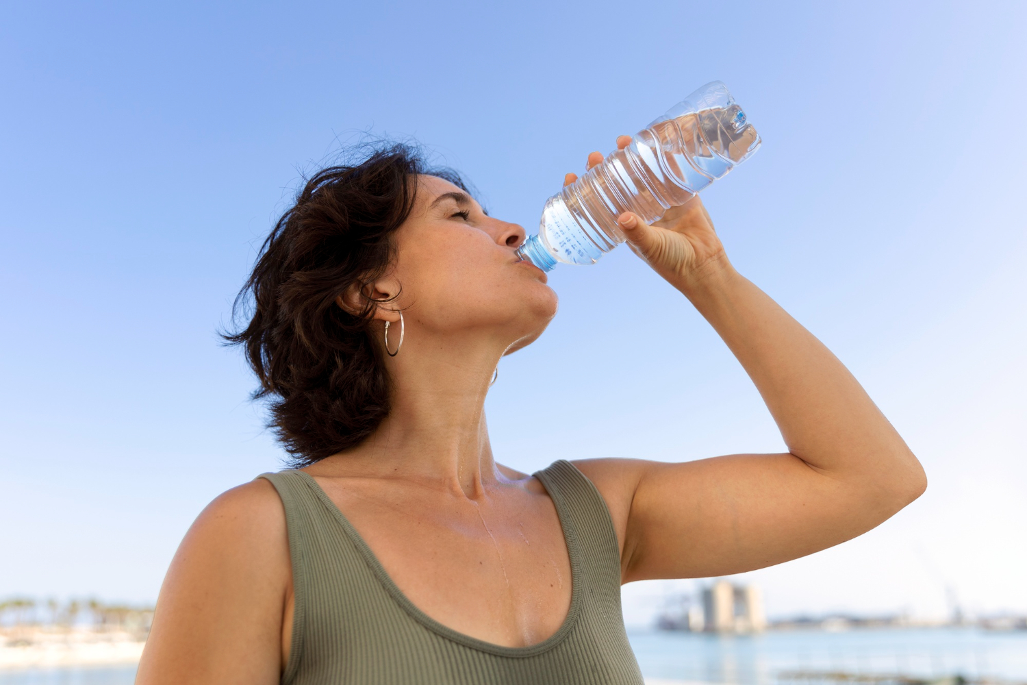 Woman staying hydrated in summer with a water bottle